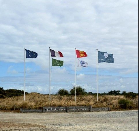 Flags above the Le Links 1912 Harry S. Colt sign at Granville