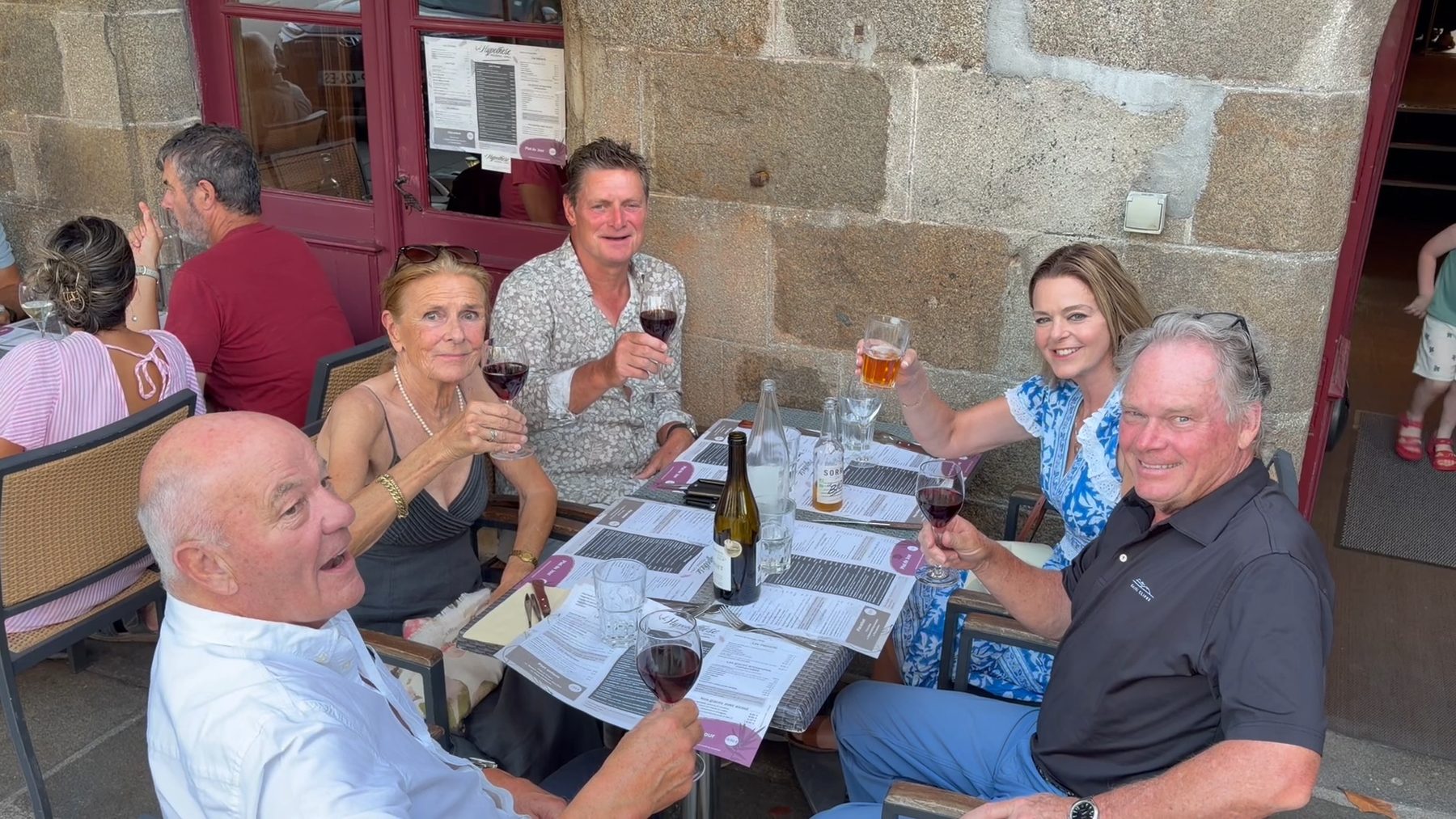 Friends raising a glass at dinner in Combourg